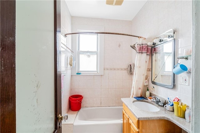 full bath with vanity and tile walls