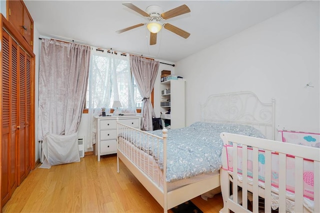 bedroom featuring wood finished floors, a ceiling fan, and a closet
