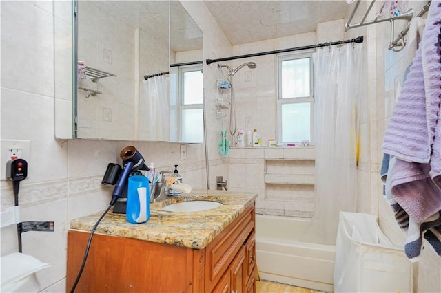 bathroom with tile walls, vanity, and shower / bath combo