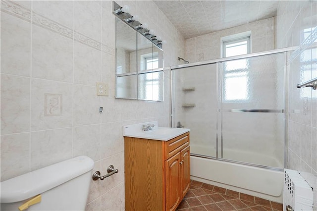 full bath with tile walls, bath / shower combo with glass door, tile patterned flooring, toilet, and radiator