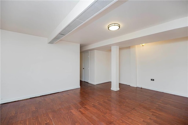 finished below grade area featuring wood finished floors and baseboards
