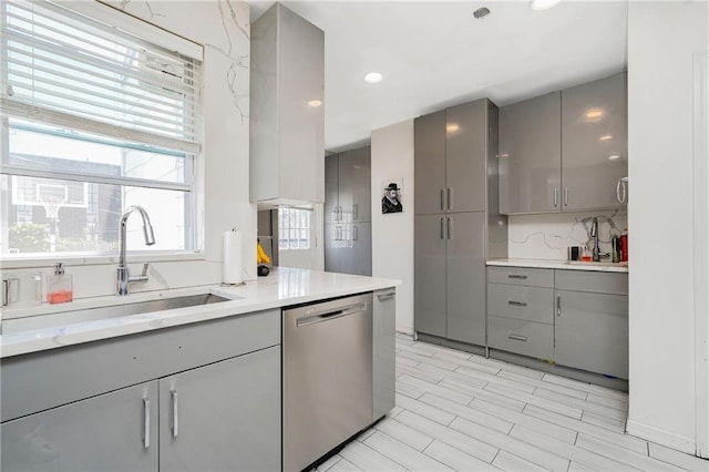 kitchen featuring gray cabinetry, dishwasher, a sink, and recessed lighting