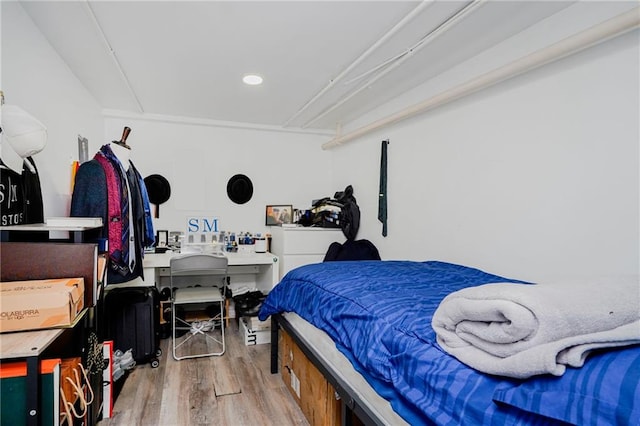bedroom with wood finished floors, recessed lighting, and an office area