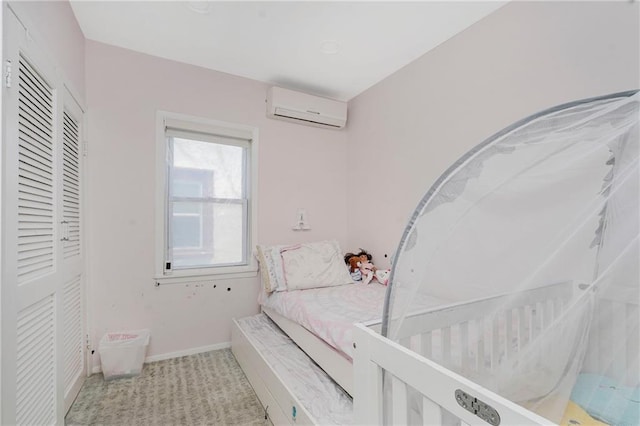 bedroom featuring a wall mounted air conditioner, carpet, and baseboards