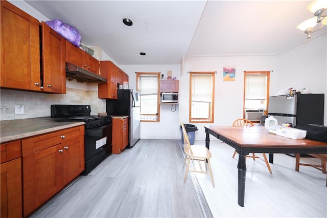 1214 74th St, Brooklyn, NY 11228 - kitchen featuring appliances with stainless steel finishes, under cabinet range hood, light wood-style flooring, backsplash, and brown cabinets