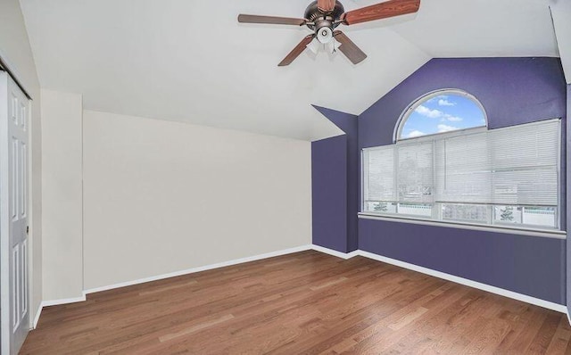 additional living space with lofted ceiling, a ceiling fan, wood finished floors, and baseboards