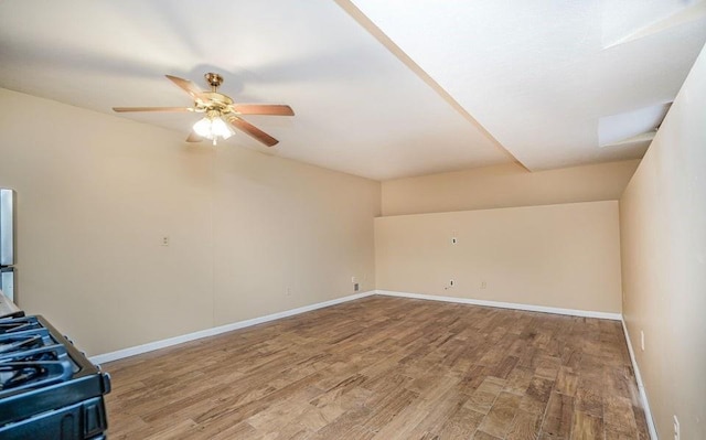 unfurnished living room featuring wood finished floors, a ceiling fan, and baseboards