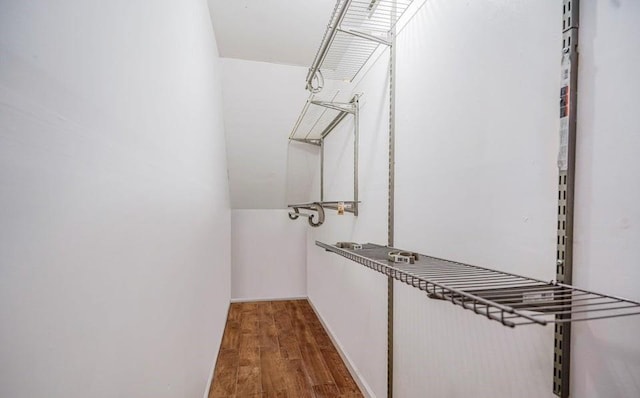 walk in closet with wood finished floors