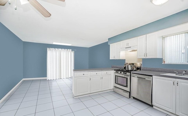 kitchen featuring appliances with stainless steel finishes, a peninsula, white cabinetry, a sink, and a ceiling fan
