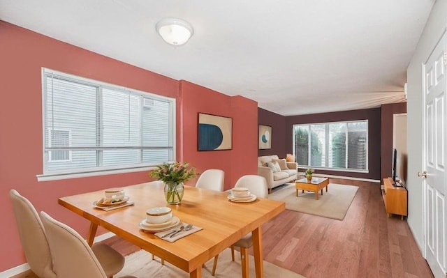 dining space featuring light wood-type flooring and baseboards