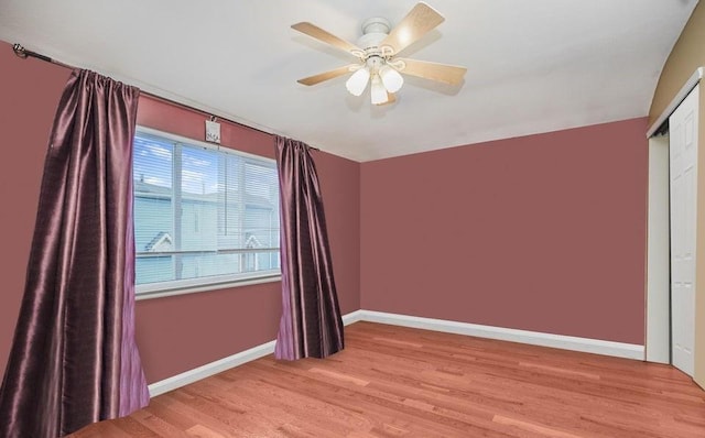 spare room with light wood-style floors, baseboards, and ceiling fan