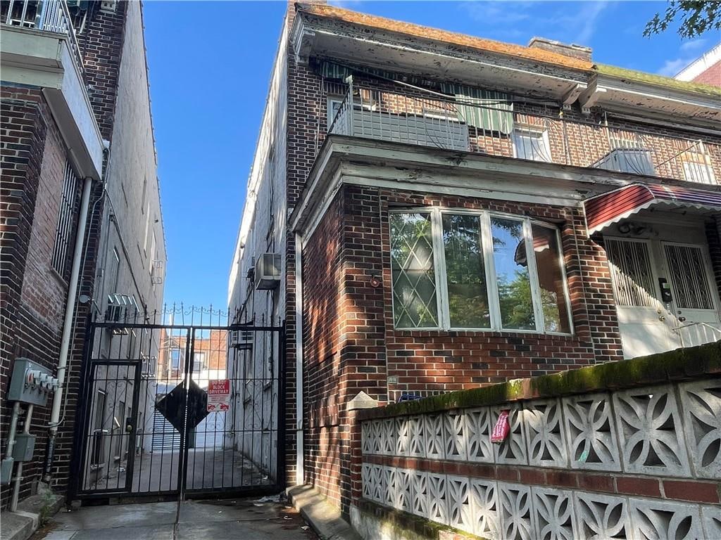 729 55th St, Brooklyn, NY 11220 - view of side of home featuring brick siding and a gate