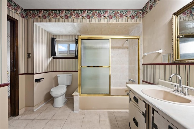 bathroom with wallpapered walls, toilet, tile patterned floors, combined bath / shower with glass door, and vanity