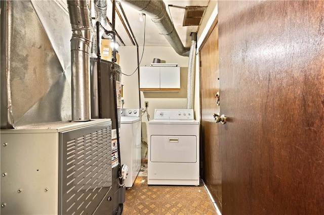 laundry area with independent washer and dryer, heating unit, tile patterned floors, and cabinet space