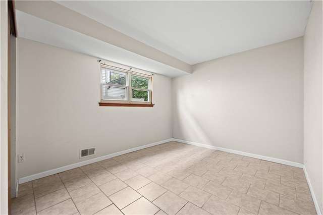 spare room featuring baseboards and light tile patterned floors