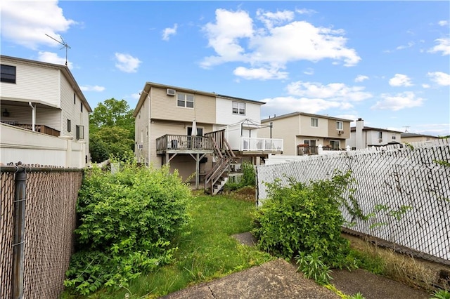 back of property featuring a fenced backyard, stairway, a residential view, and a wooden deck
