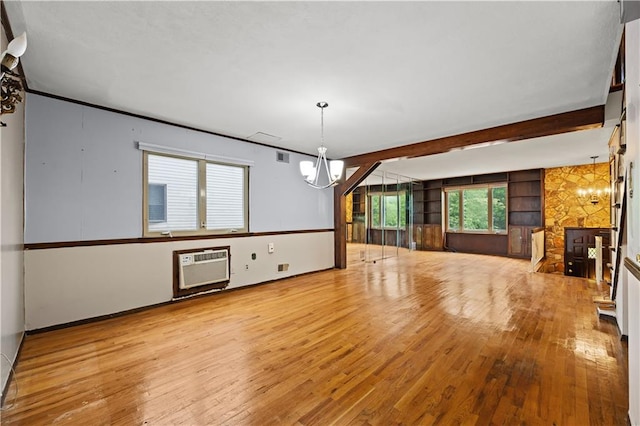 unfurnished living room with a chandelier, hardwood / wood-style flooring, and beam ceiling
