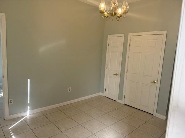 1113 68th St, Brooklyn, NY 11219 - unfurnished room featuring light tile patterned floors, a chandelier, and baseboards