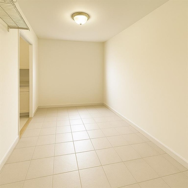 empty room with light tile patterned floors and baseboards