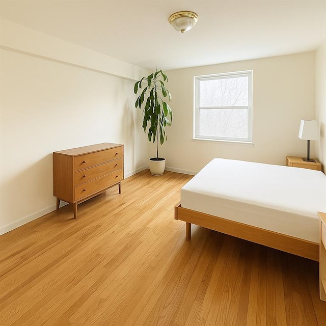bedroom featuring baseboards and light wood-type flooring