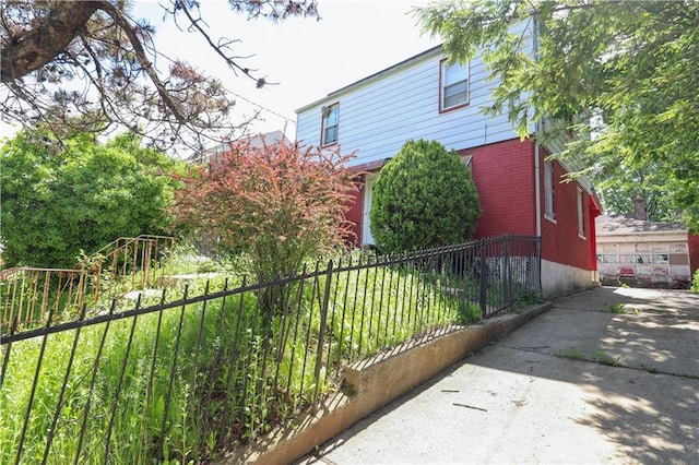 view of home's exterior with brick siding and fence