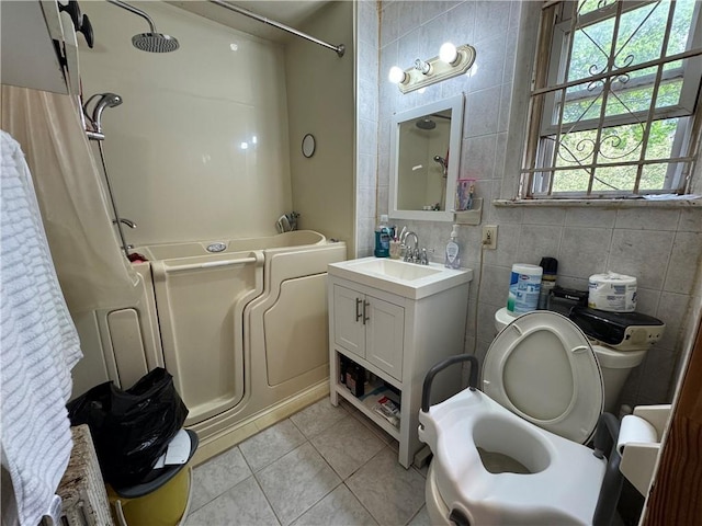 bathroom featuring tile patterned floors, tile walls, toilet, and vanity