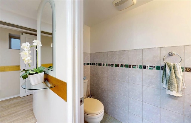 2291 E 21st St, Brooklyn, NY 11229 - bathroom featuring tile walls, toilet, and a wainscoted wall