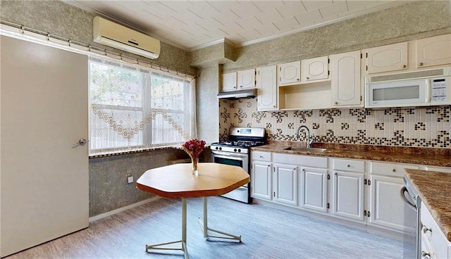 2291 E 21st St, Brooklyn, NY 11229 - kitchen featuring stainless steel appliances, a sink, an AC wall unit, ornamental molding, and light wood-style floors