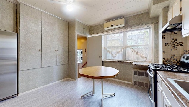 2291 E 21st St, Brooklyn, NY 11229 - kitchen with appliances with stainless steel finishes, a wall unit AC, ornamental molding, light wood finished floors, and radiator heating unit