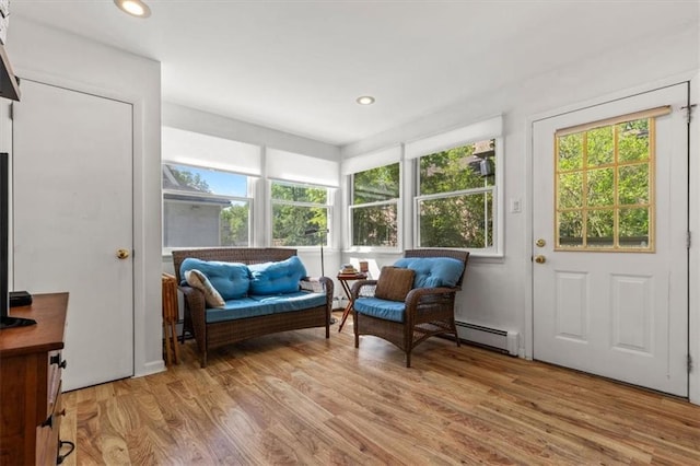 sitting room with a baseboard heating unit, light wood-style floors, and recessed lighting