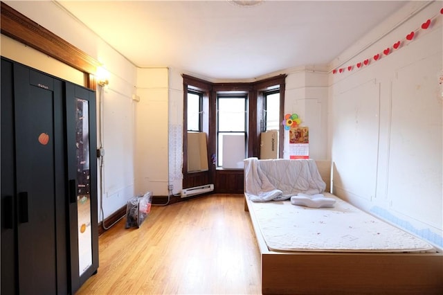 642 56th St, Brooklyn, NY 11220 - bedroom with a baseboard heating unit, light wood-style floors, and baseboards