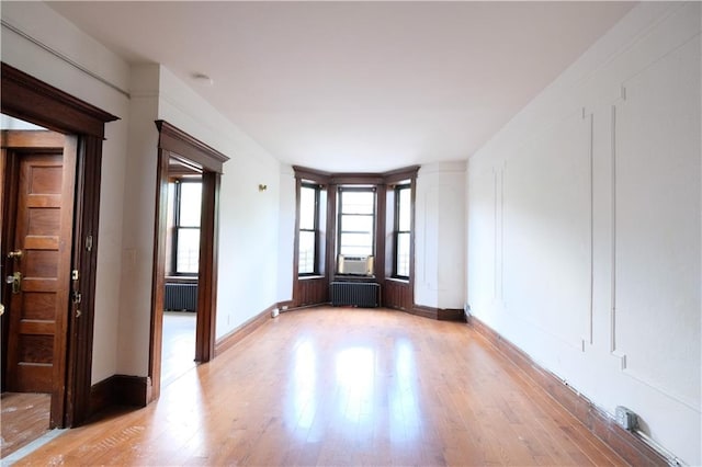 642 56th St, Brooklyn, NY 11220 - empty room with radiator, light wood-style floors, and baseboards