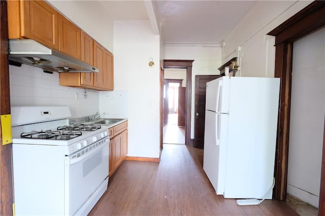 642 56th St, Brooklyn, NY 11220 - kitchen featuring white appliances, under cabinet range hood, wood finished floors, a sink, and backsplash