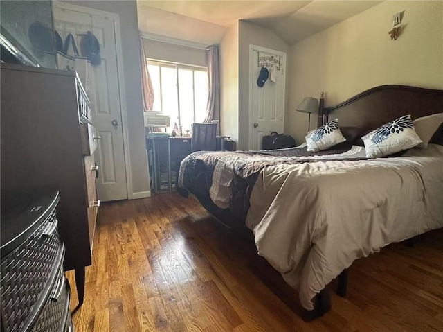 bedroom with wood finished floors and vaulted ceiling