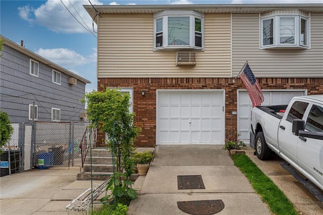 view of front of home featuring brick siding, an attached garage, concrete driveway, and fence
