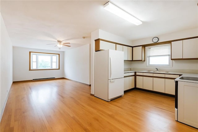 kitchen featuring freestanding refrigerator, electric range oven, plenty of natural light, and light wood-style floors