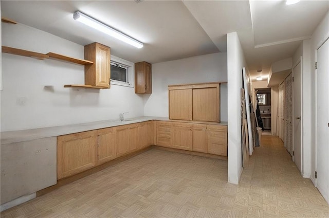 kitchen with a sink, open shelves, light countertops, and light brown cabinets