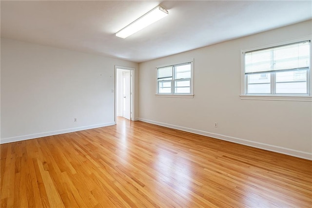 empty room with light wood-type flooring and baseboards