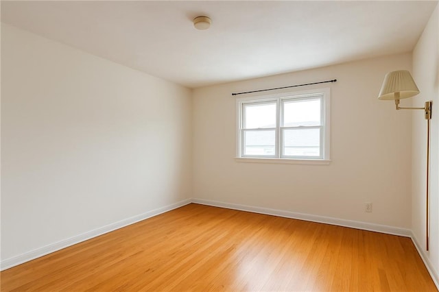 empty room featuring light wood-type flooring and baseboards