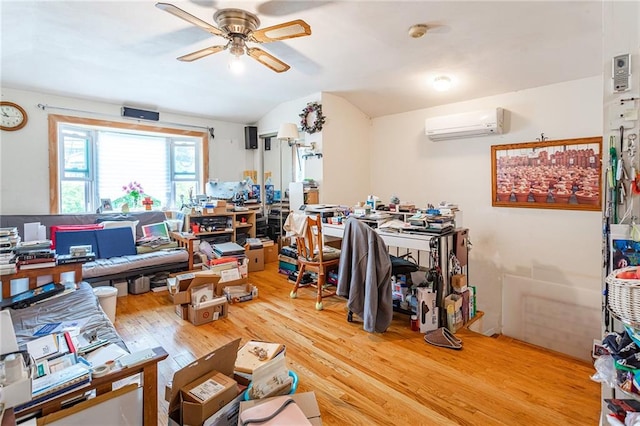 office area with a wall mounted AC, a ceiling fan, and light wood-type flooring