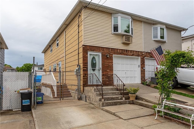 view of front of home featuring driveway, an attached garage, fence, brick siding, and a gate