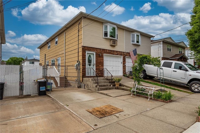 view of property with fence, a garage, driveway, and brick siding