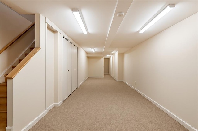 hall with light carpet, stairway, and baseboards
