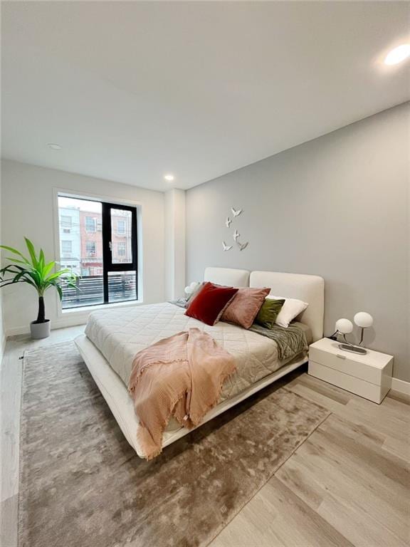 bedroom with wood finished floors, baseboards, access to outside, and recessed lighting