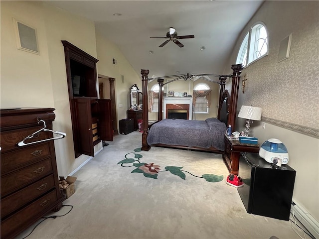 bedroom featuring baseboard heating, lofted ceiling, ceiling fan, and light carpet