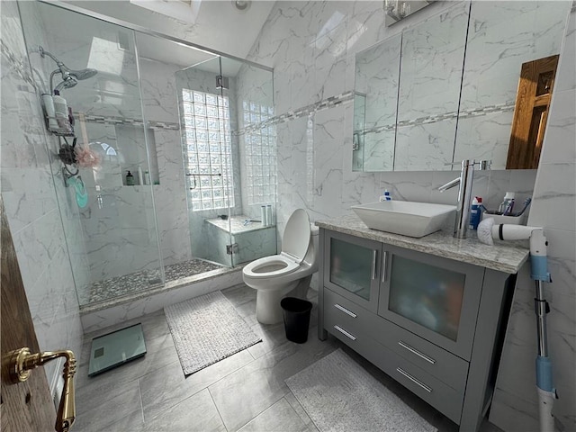 full bath with tile walls, a marble finish shower, toilet, and vanity