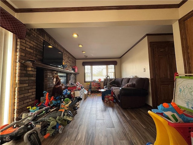 living room featuring wood finished floors, crown molding, a brick fireplace, and recessed lighting