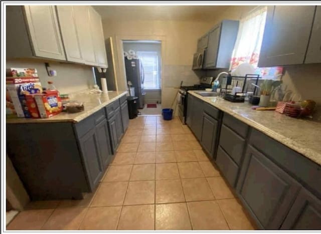 19907 100th Ave, Hollis, NY 11423 - kitchen featuring appliances with stainless steel finishes, gray cabinetry, light tile patterned flooring, and light countertops