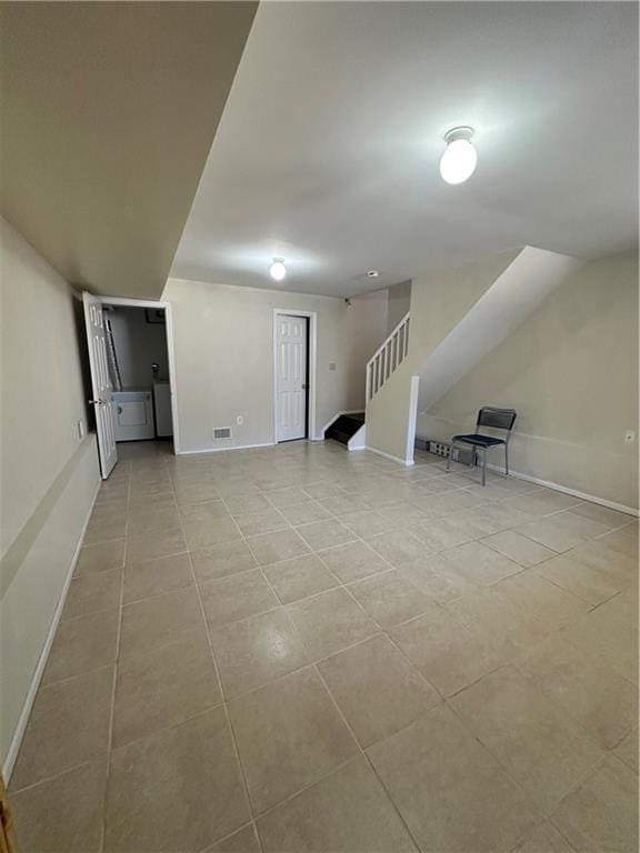 below grade area featuring light tile patterned floors, stairs, and baseboards