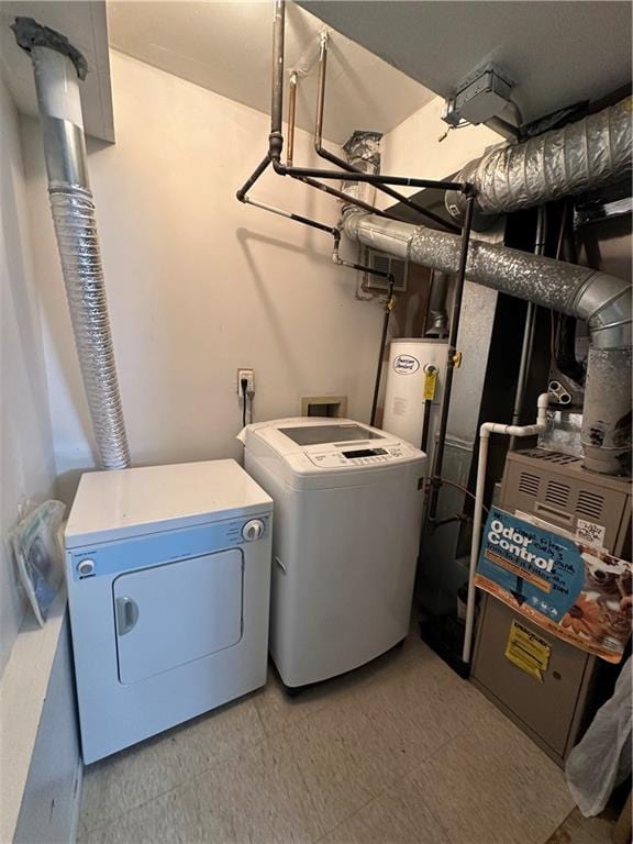 laundry room with washer and clothes dryer, light flooring, and gas water heater